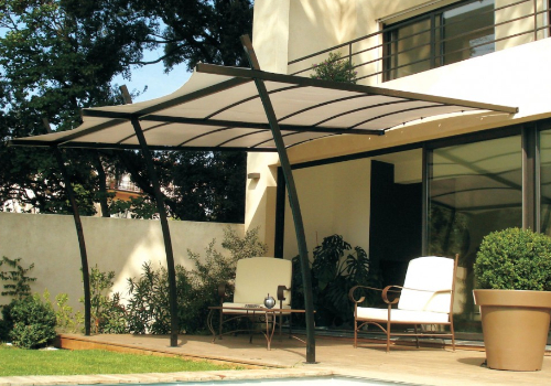 tonnelle pergola en acier et voile d'ombrage en polyester avec un salon de jardin dessous.